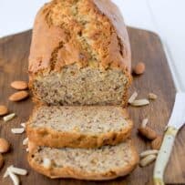 Almond banana bread on a cutting board with a butter knife