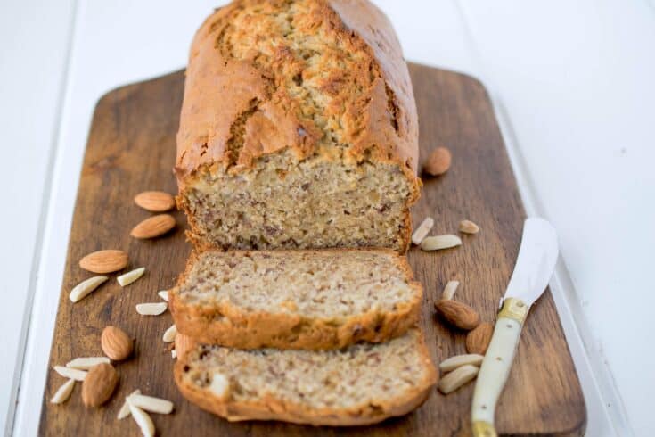 Almond banana bread on a cutting board with a butter knife