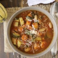 A bowl of minestrone soup with colorful vegetables from above