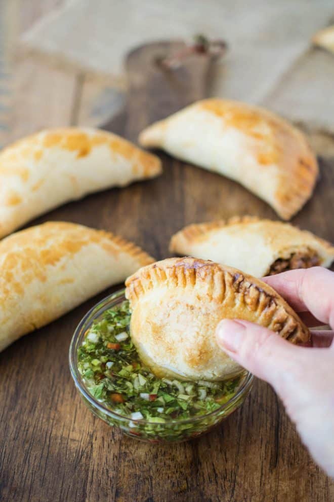 Dipping an empanada in the chimichurri