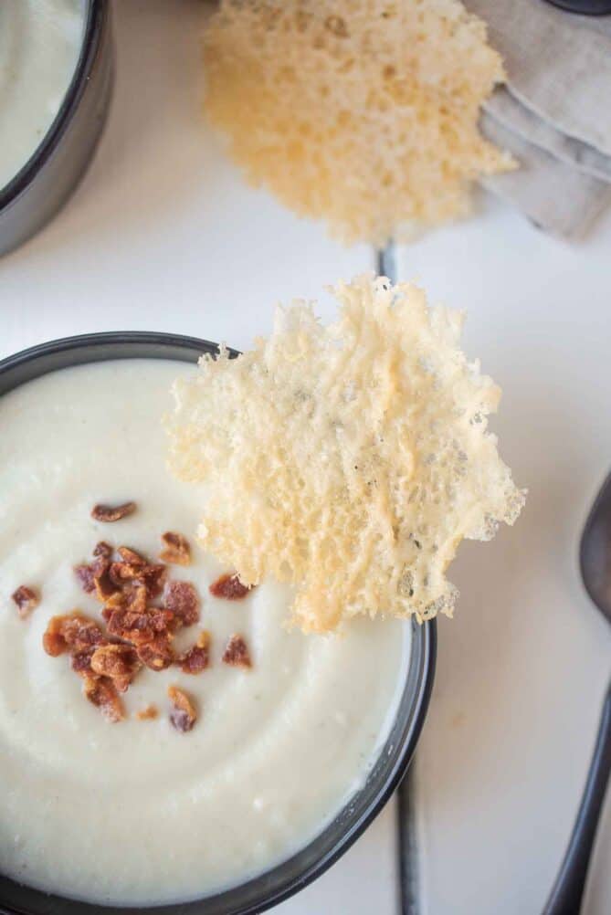 A Parmesan crisp on the side of a bowl of soup