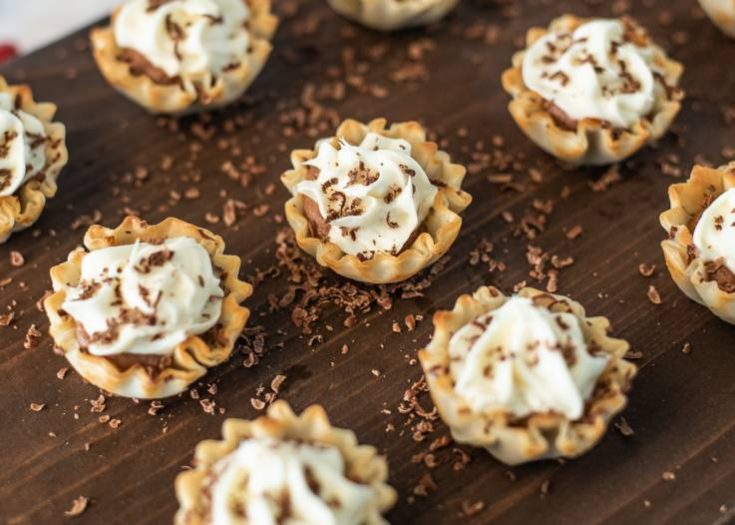 A selection of Chocolate Mousse Cream Cheese Phyllo Dessert Cups on a serving board with shaved chocolate