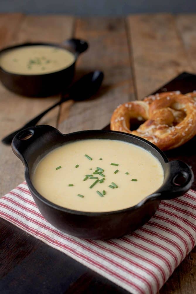 2 black bowls of creamy soup on a red and white striped napkin