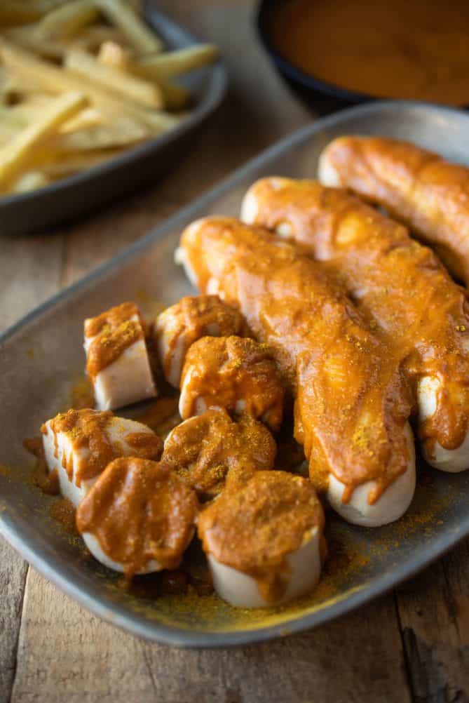A closeup of slices German sausage covered with curry ketchup