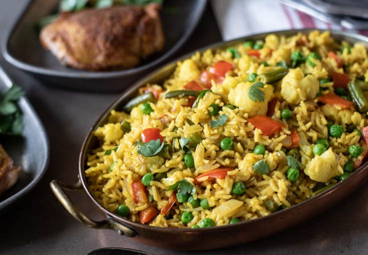 An oval serving dish of the rice served with chicken