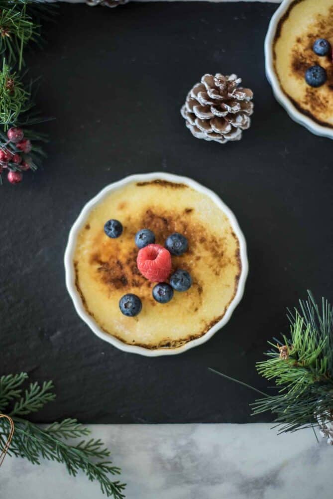Eggnog creme brûlée viewed from overhead with pine cones