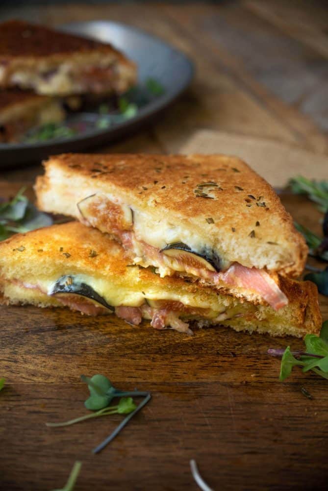 Cheese and fresh fig oozing out of a half of grilled cheese