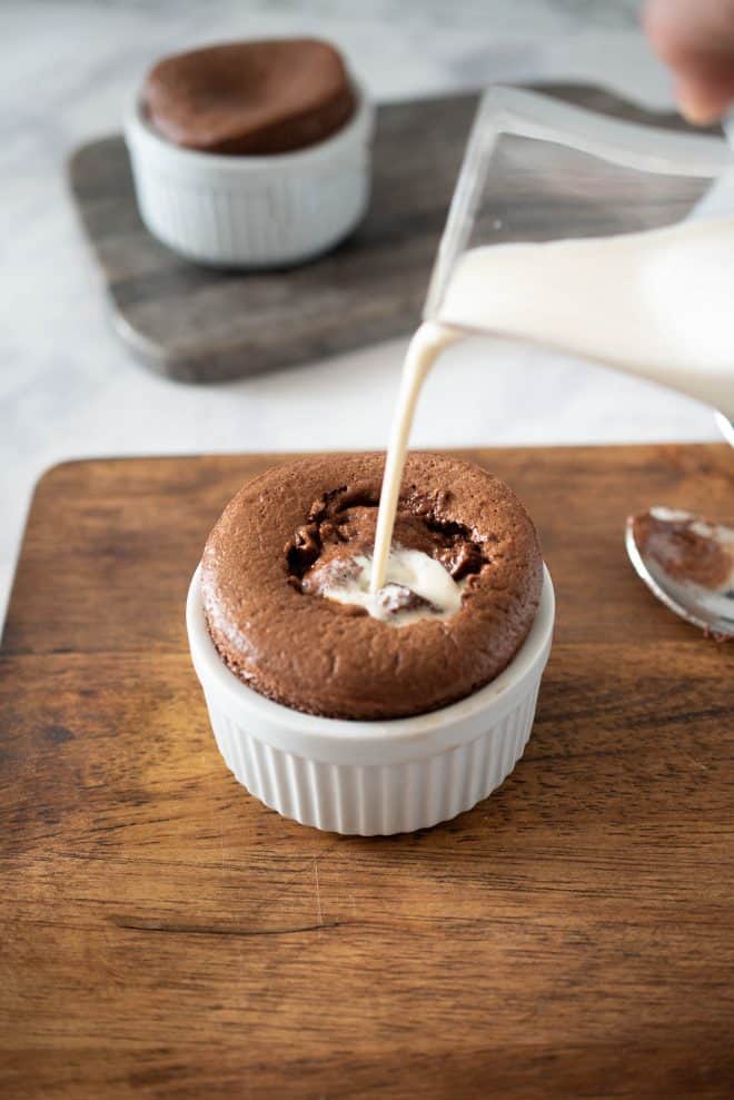 Pouring vanilla sauce into the center of the soufflé