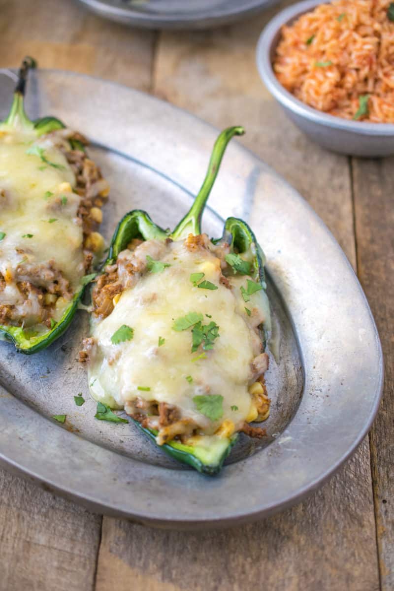Grilled beef stuffed poblano peppers on a pewter plate