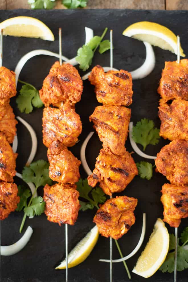 Grilled Tandoori Chicken Kebabs brings everyones favorite tandoori Indian dish into our own kitchens. Chicken is marinated in yogurt and delicious Indian spices then grilled to achieve the closest flavor you can get without a tandoor oven. #tandoorichicken #grilled #indian
