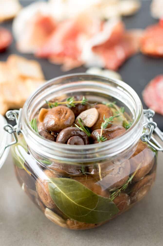 A jar filled with mushrooms and herbs