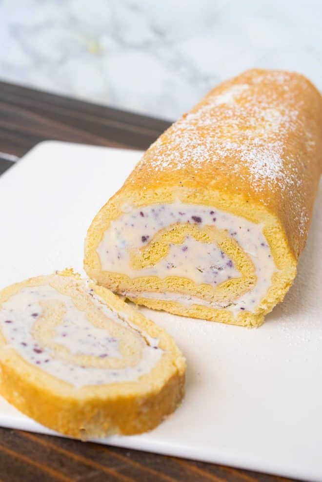 Ice cream swiss roll with a slice cut on a white plate