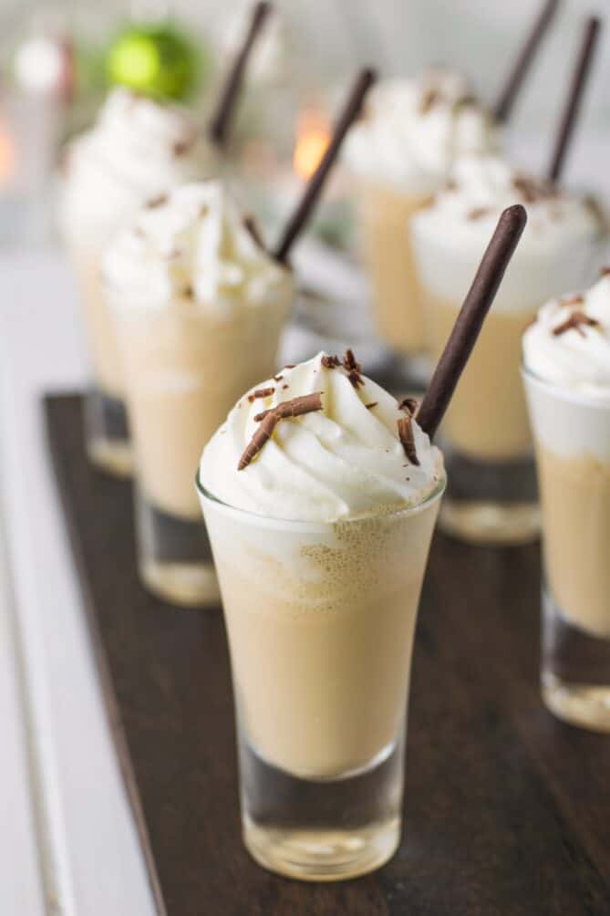 A side view of a shot glass of coffee milkshake