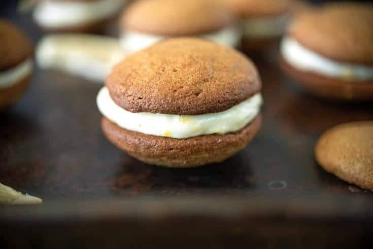 A side image of a cookie where you can see the flecks of lemon zest in the cream cheese filling