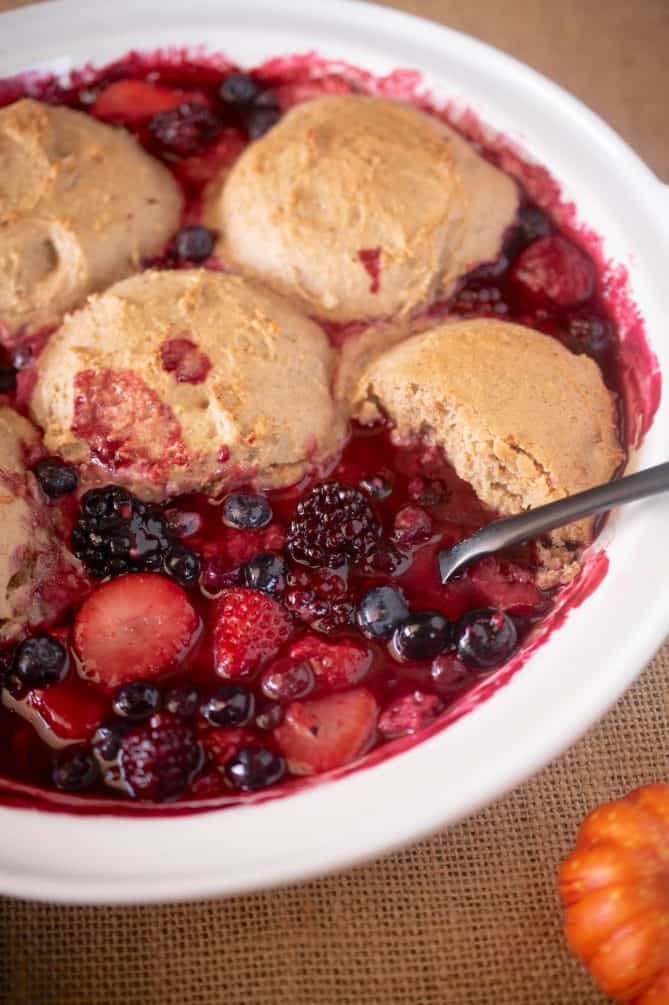 Strawberries, blueberries and blackberries in delicious juices in a white bowl