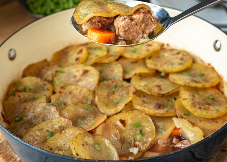 A spoonful of lamb, carrot and sliced potato