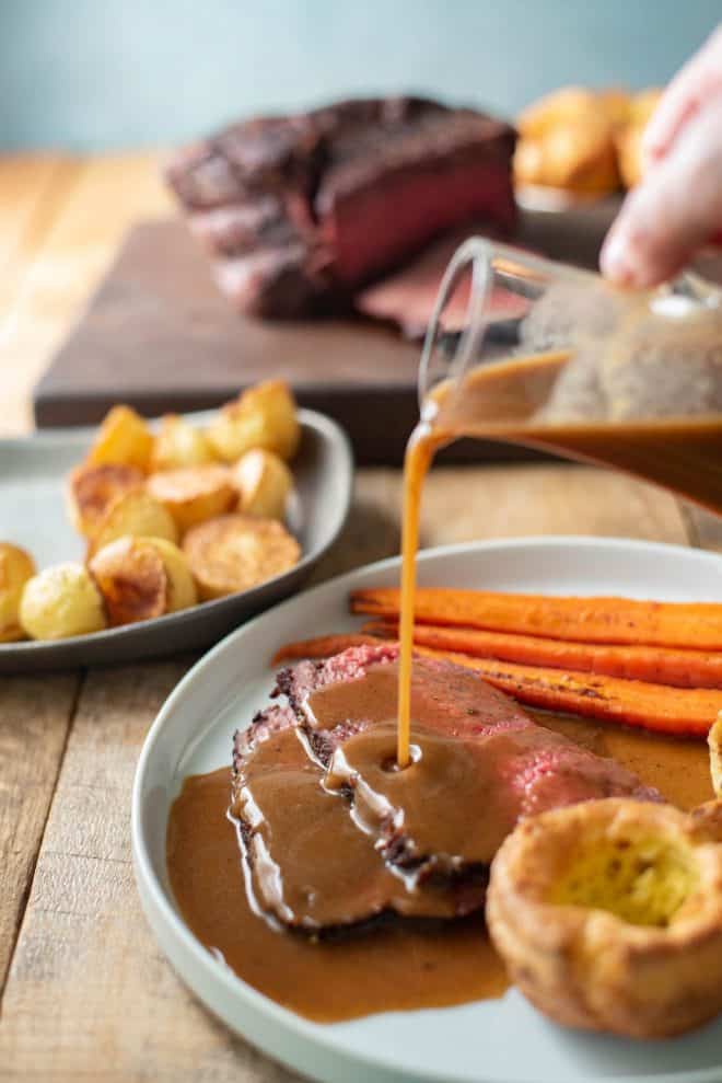 Pouring gravy over sliced roast beef