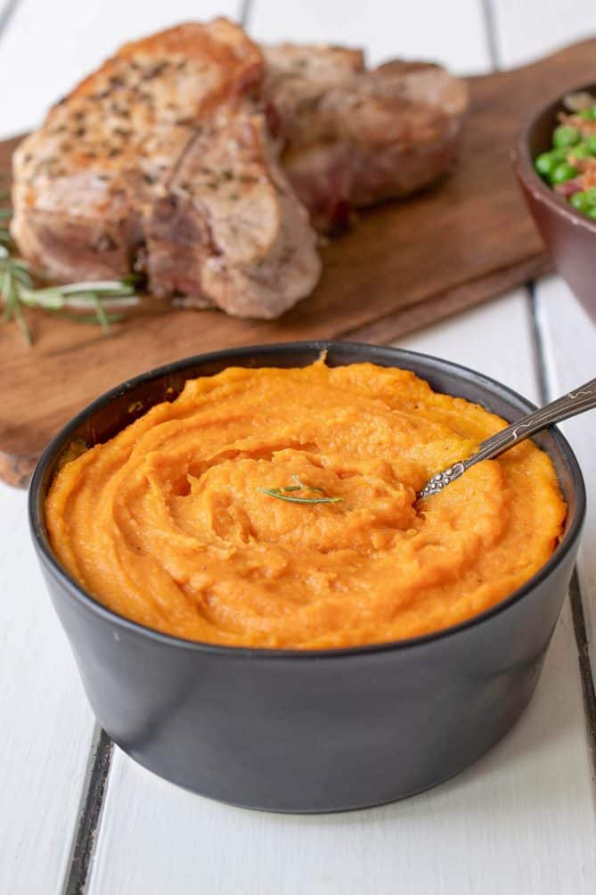 Vegan roasted carrots and parsnip pureed and served in a black bowl