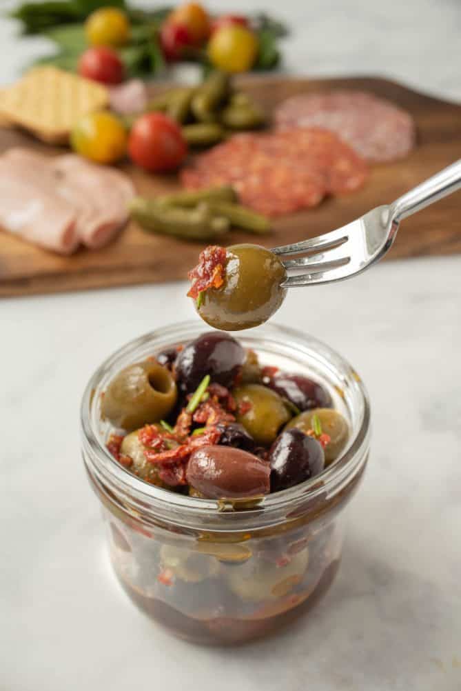 A green olive on a fork