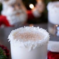 Very festive glass of milk with a lovely coconut rim and a ceramic Santa in the background