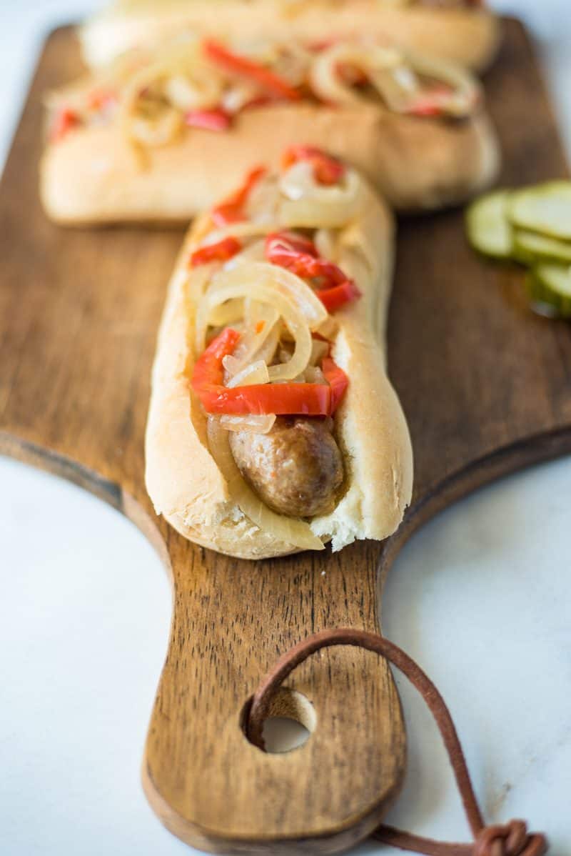 Slow cooker beer brats with peppers and onions are the perfect, easy cookout meal for a crowd. Brats are slow cooked in German beer along with peppers and onions, pile onto a bun and you’re set.