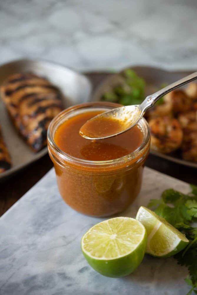 Using a spoon to spoon some sauce out of the jar