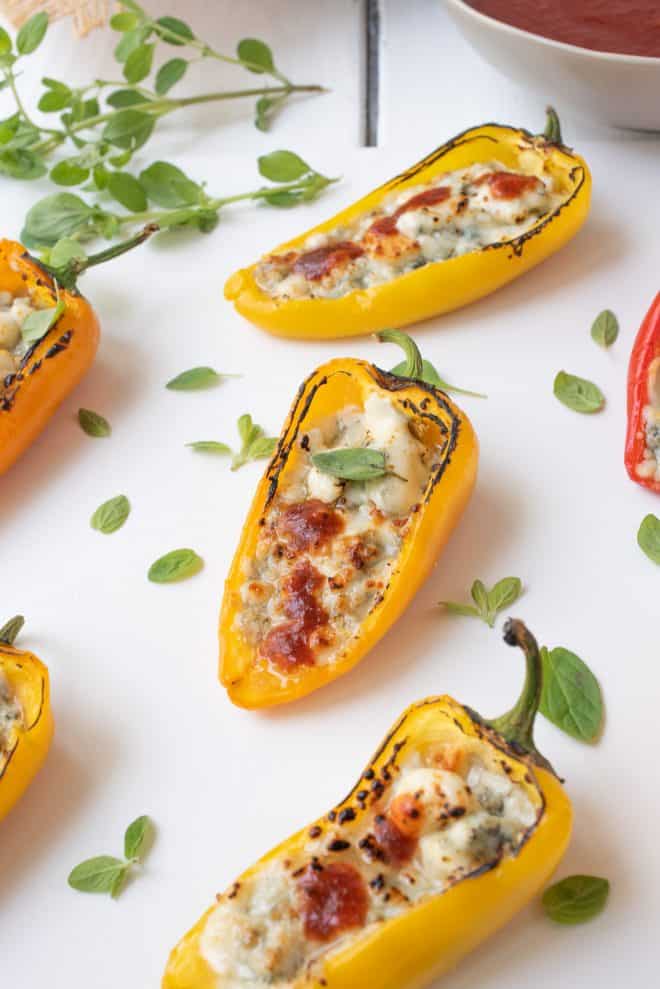 A yellow mini sweet pepper stuffed with blue cheese and topped with hot sauce