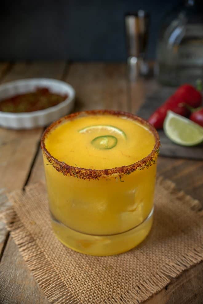 A short glass of Spicy Jalapeño Mango Margarita on a mat