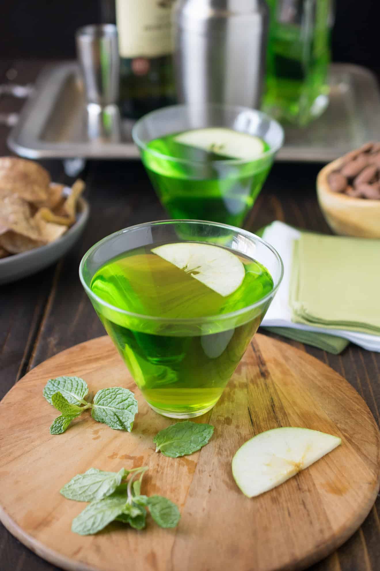 A vibrant St Patrick's Day green Dublin cocktail garnished with sliced apple