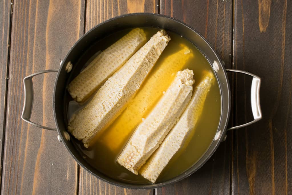 Corn Cobbs in a pan with vegetable broth to make corn broth