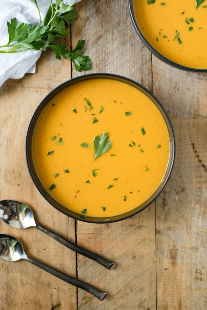 A bowl of butternut squash soup viewed from overhead