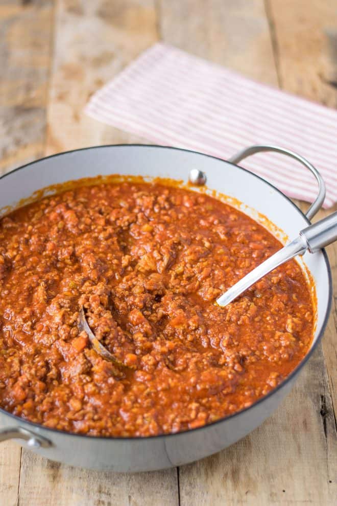 A serving spoon in a pan of Bolognese sauce