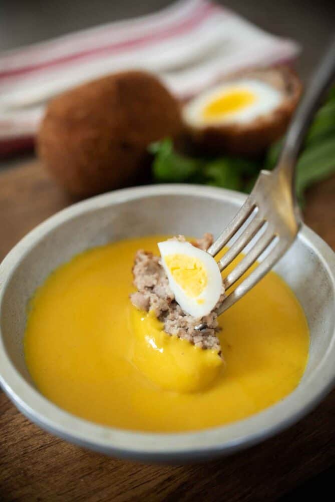 Dipping a bite of food into mustard sauce
