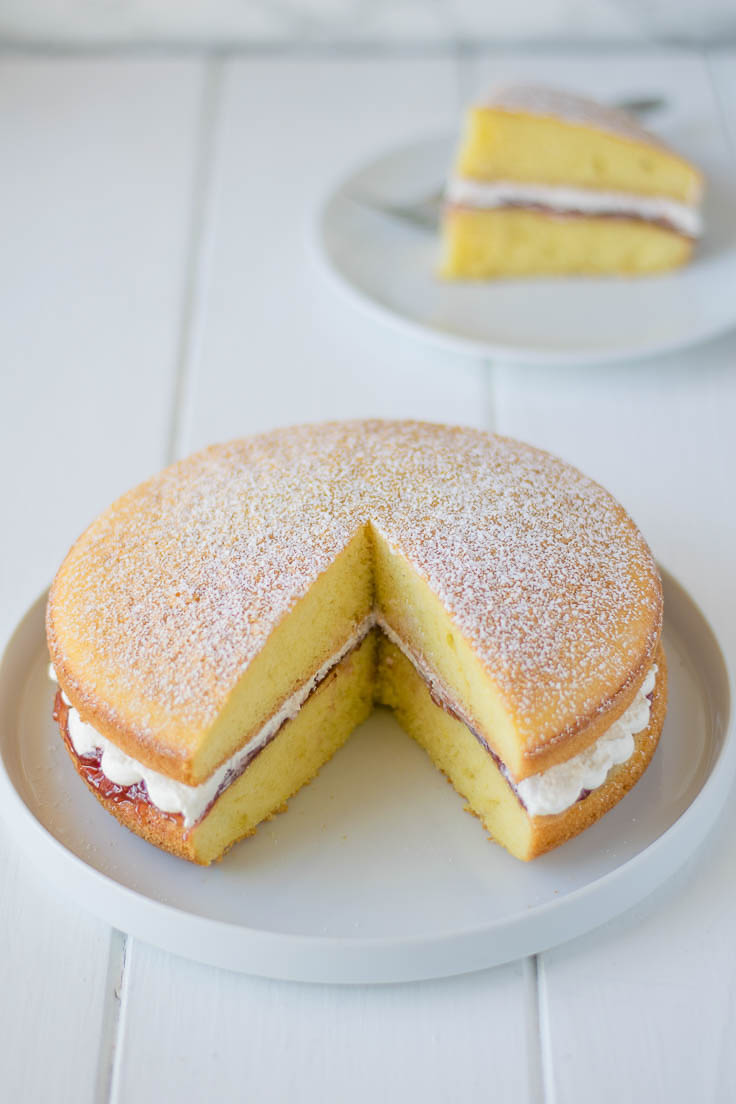 A whole sponge cake with a slice taken out