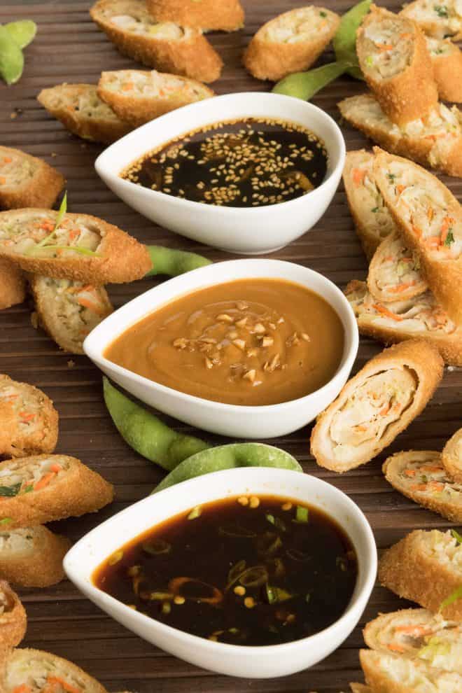 3 white teardrop bowls of Asian dipping sauces