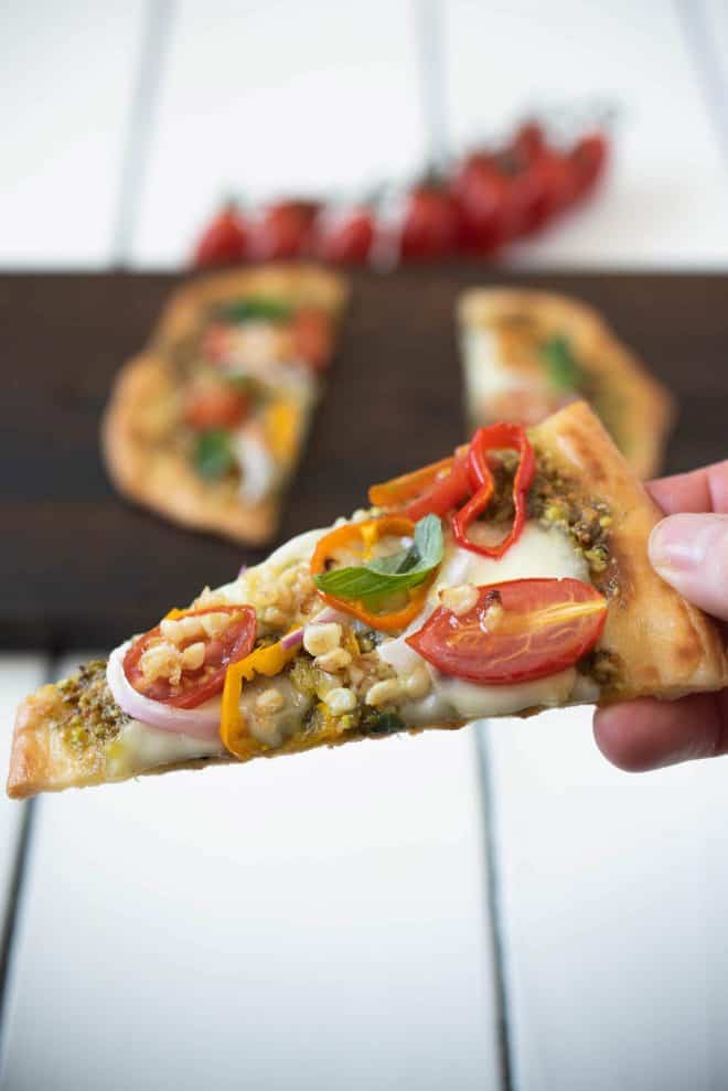 Holding a slice of the flatbread pizza